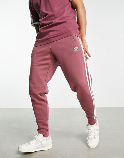 adidas Originals adicolor three stripe joggers in quiet crimson