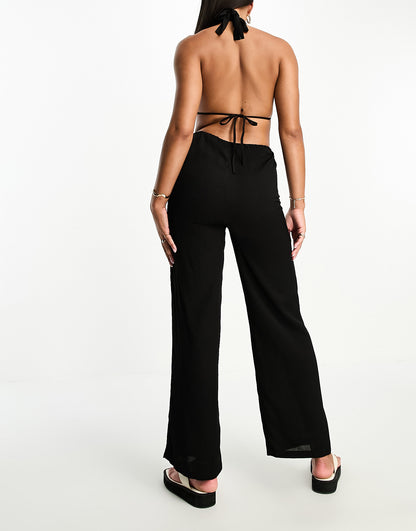 The Frolic tanzanite cut out tie detail halter neck jumpsuit in black